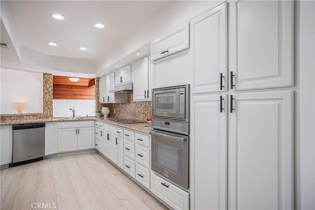 kitchen featuring appliances with stainless steel finishes, a sink, under cabinet range hood, recessed lighting, and white cabinetry