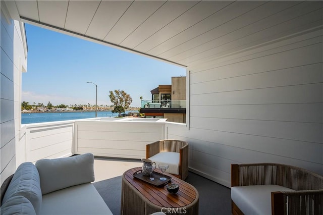 view of patio / terrace with a water view and a balcony