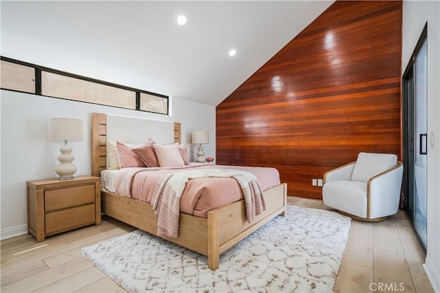 bedroom featuring light wood-type flooring, recessed lighting, wood walls, and high vaulted ceiling