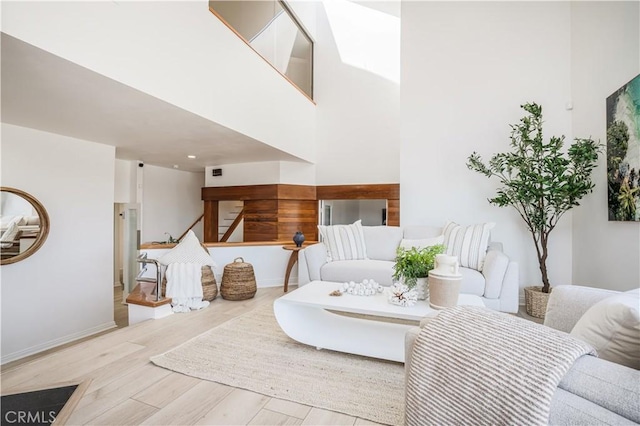 living room with baseboards, stairs, and wood finished floors