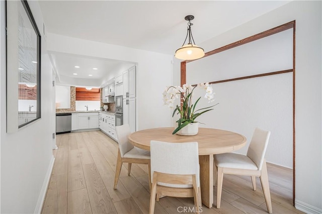 dining space with baseboards and light wood finished floors