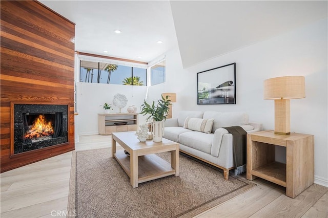 living area with a premium fireplace, recessed lighting, and wood finished floors