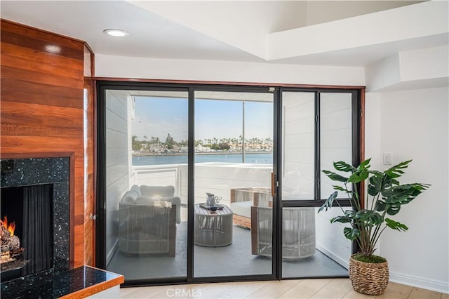 doorway to outside with baseboards, a fireplace, and recessed lighting