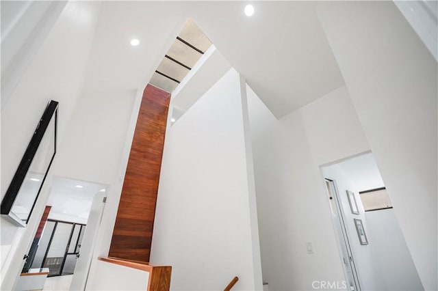 hall with recessed lighting and a towering ceiling