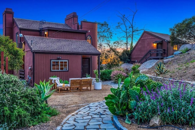 exterior space featuring an outdoor living space, an outbuilding, and a patio area