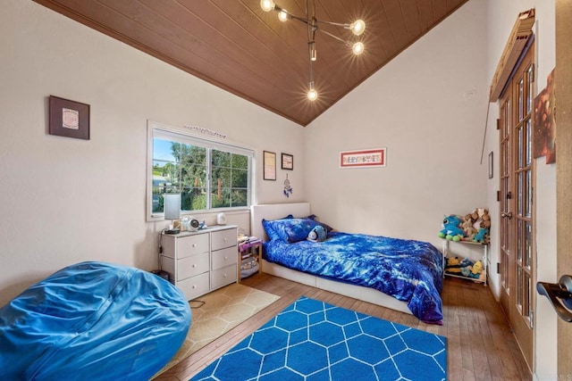 bedroom with wood ceiling, wood-type flooring, a ceiling fan, and lofted ceiling