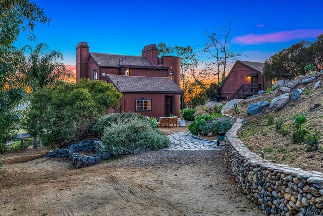 exterior space with a chimney and roof with shingles