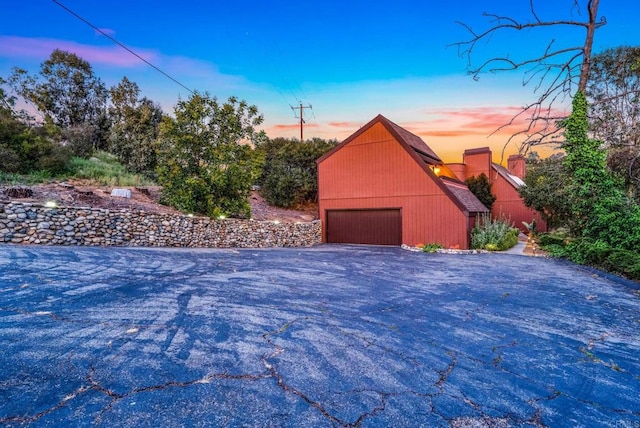 property exterior at dusk with an outbuilding and a detached garage