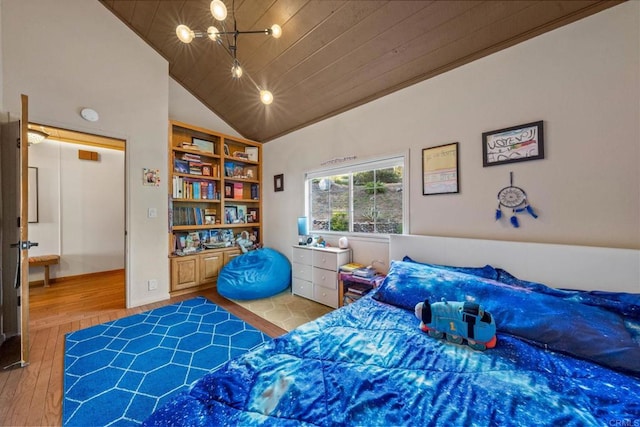 bedroom featuring high vaulted ceiling and wood finished floors