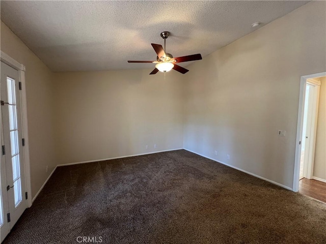 unfurnished room with baseboards, ceiling fan, dark colored carpet, and a textured ceiling