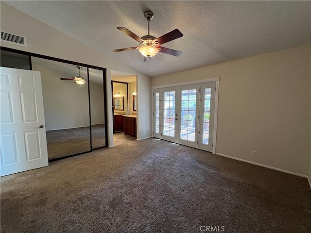 unfurnished bedroom with carpet floors, visible vents, access to exterior, and lofted ceiling