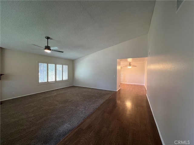 carpeted spare room featuring baseboards, a textured ceiling, ceiling fan, and wood finished floors