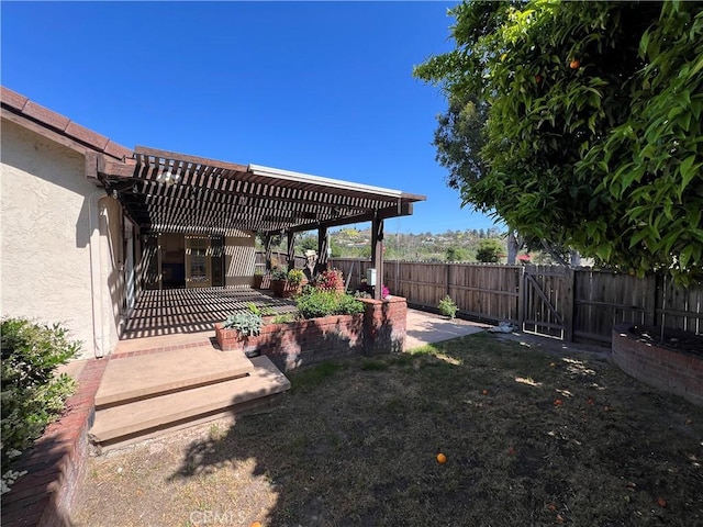 view of yard featuring a fenced backyard, a patio area, a pergola, and a gate