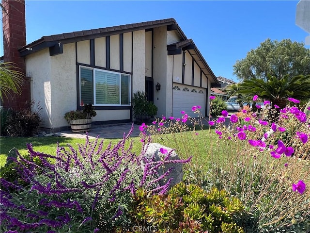 view of side of home with a garage and stucco siding