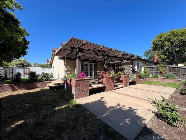 back of property featuring french doors, a patio area, a fenced backyard, a pergola, and stucco siding