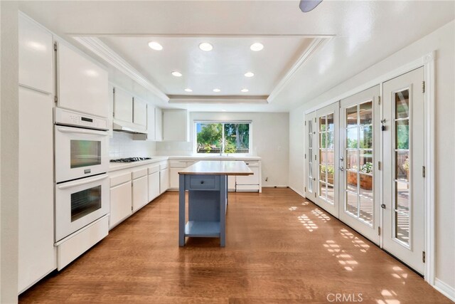 31341 Via Sonora, San Juan Capistrano, CA 92675 - kitchen with white appliances, white cabinets, french doors, and light wood-style floors