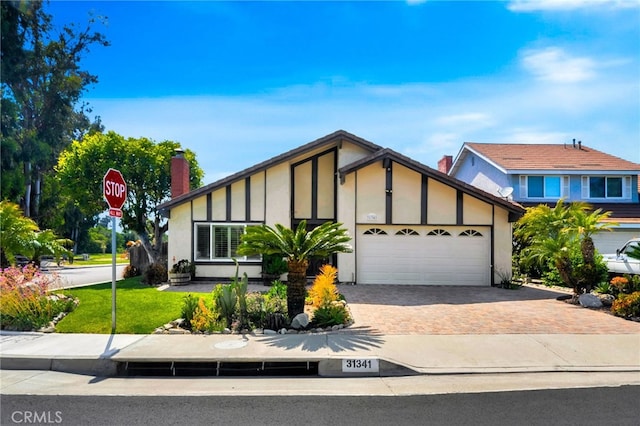 31341 Via Sonora, San Juan Capistrano, CA 92675 - view of front facade featuring driveway, a chimney, a front lawn, an attached garage, and stucco siding