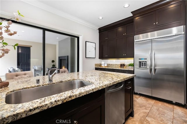 12 Starflower, Lake Forest, CA 92630 - kitchen featuring stainless steel appliances, light stone countertops, ornamental molding, dark brown cabinetry, and recessed lighting