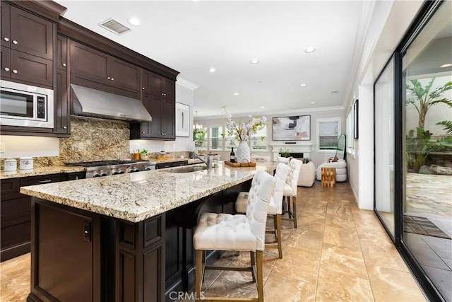 12 Starflower, Lake Forest, CA 92630 - kitchen with stainless steel microwave, exhaust hood, crown molding, tasteful backsplash, and open floor plan