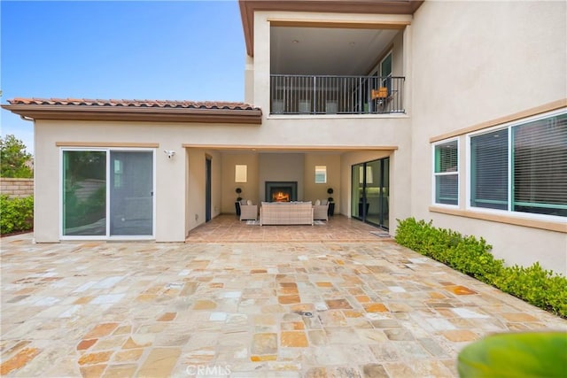 12 Starflower, Lake Forest, CA 92630 - back of house with stucco siding, an outdoor living space with a fireplace, and a patio