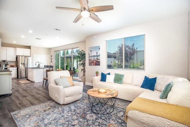 living area with dark wood-style flooring, ceiling fan, visible vents, and recessed lighting