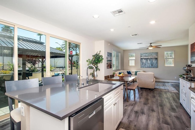kitchen featuring visible vents, stainless steel dishwasher, a sink, white cabinets, and recessed lighting