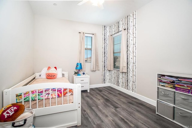 bedroom featuring baseboards, ceiling fan, and dark wood-type flooring