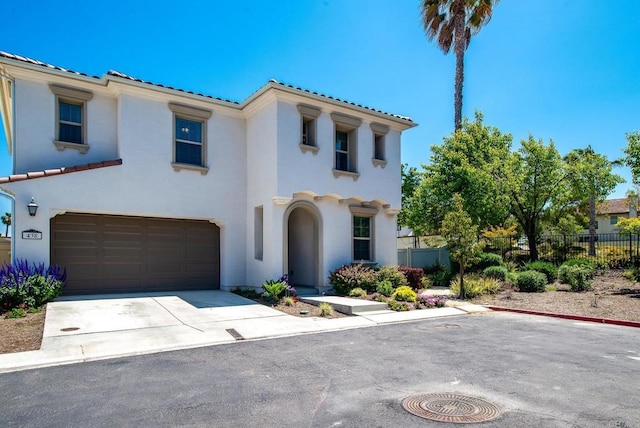 mediterranean / spanish home featuring fence, stucco siding, and a tile roof