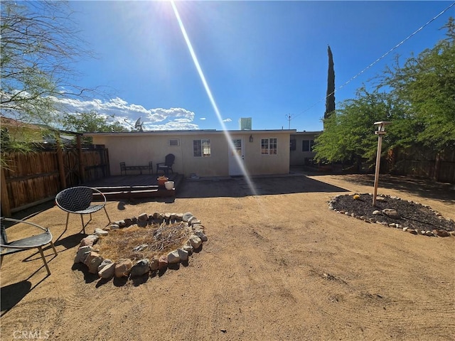 back of property featuring stucco siding and fence