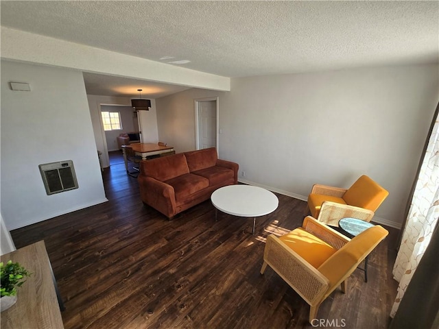 living area with baseboards, a textured ceiling, heating unit, and wood finished floors