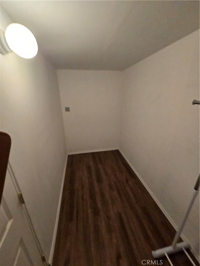 hallway with baseboards and dark wood-style flooring