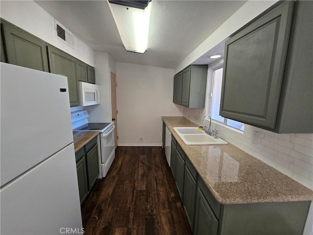 kitchen featuring visible vents, dark wood-style flooring, white appliances, a sink, and backsplash