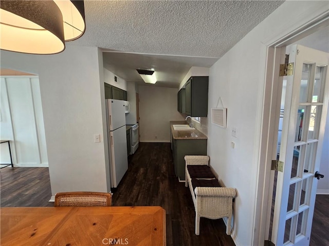 corridor with dark wood-style flooring, baseboards, a sink, and a textured ceiling