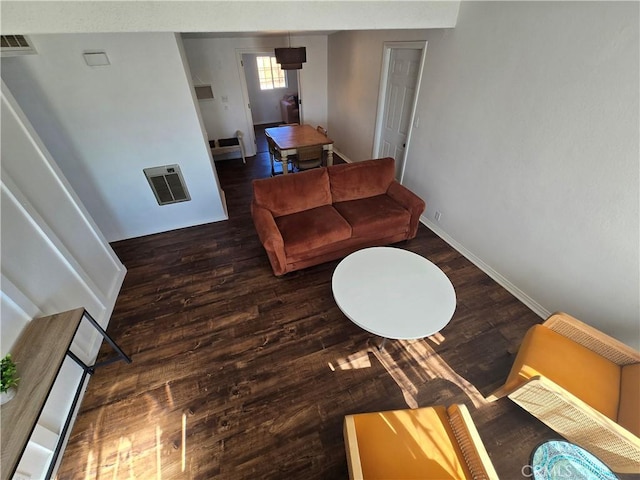 living room with visible vents, baseboards, and wood finished floors