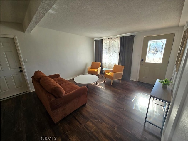 living area featuring baseboards, a textured ceiling, and wood finished floors