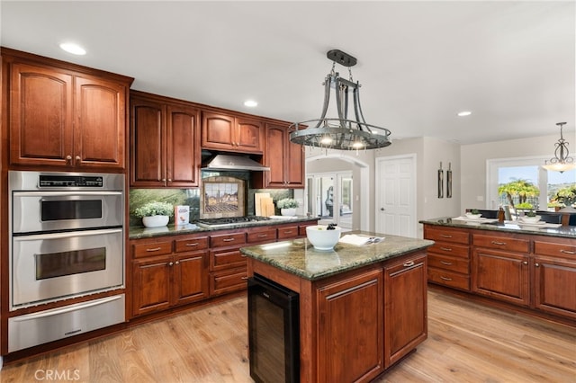 2465 Via Oeste Dr, Fallbrook, CA 92028 - kitchen with a warming drawer, stainless steel appliances, beverage cooler, a kitchen island, and under cabinet range hood