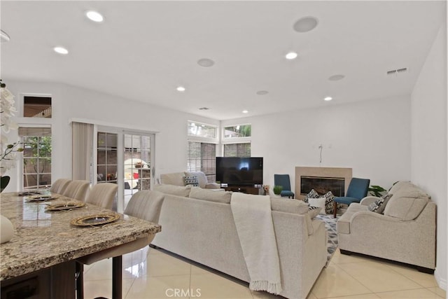 living room with light tile patterned floors, a glass covered fireplace, recessed lighting, and visible vents