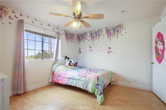 bedroom with baseboards, a ceiling fan, and light wood-type flooring