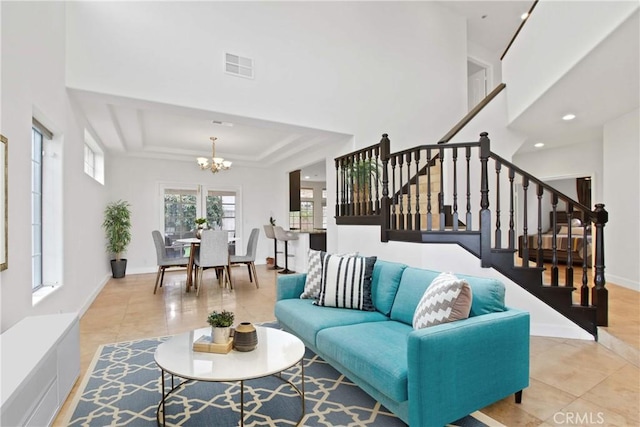 living area featuring tile patterned floors, stairs, a chandelier, and visible vents