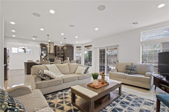 living room featuring recessed lighting, light tile patterned floors, a notable chandelier, and visible vents