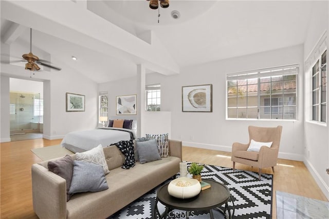 living room with vaulted ceiling with beams, ceiling fan, baseboards, and light wood-style flooring
