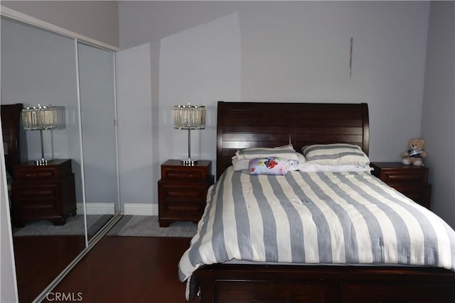 bedroom with baseboards, a closet, and wood finished floors