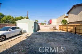 view of yard featuring fence and an outbuilding