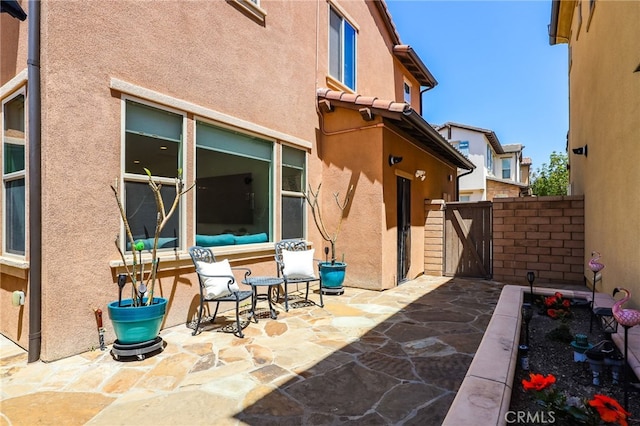 view of patio featuring fence and a gate