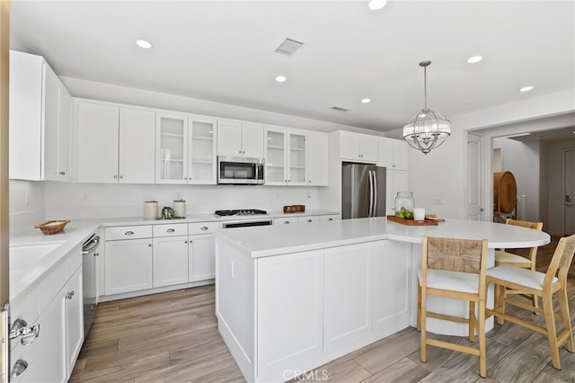 kitchen featuring a center island, stainless steel appliances, recessed lighting, and visible vents