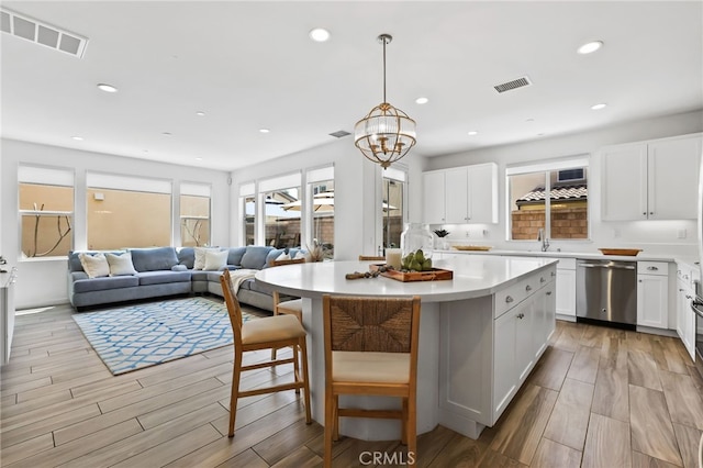 kitchen featuring a sink, visible vents, light wood-style flooring, and dishwasher