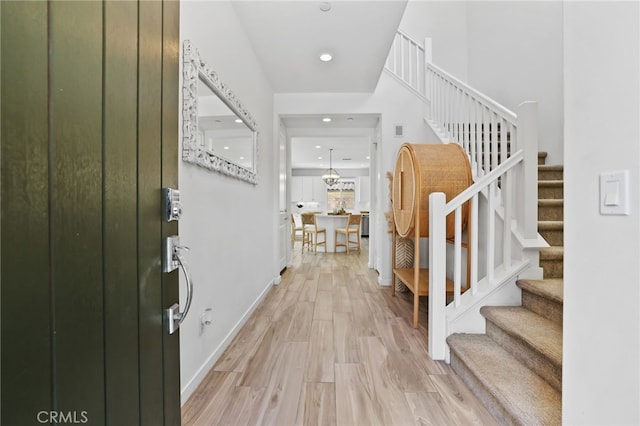 entrance foyer featuring stairway, baseboards, recessed lighting, and light wood-type flooring