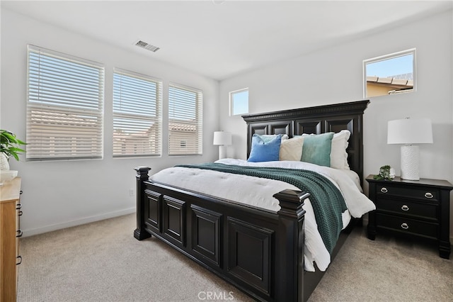 bedroom with visible vents, baseboards, and light carpet