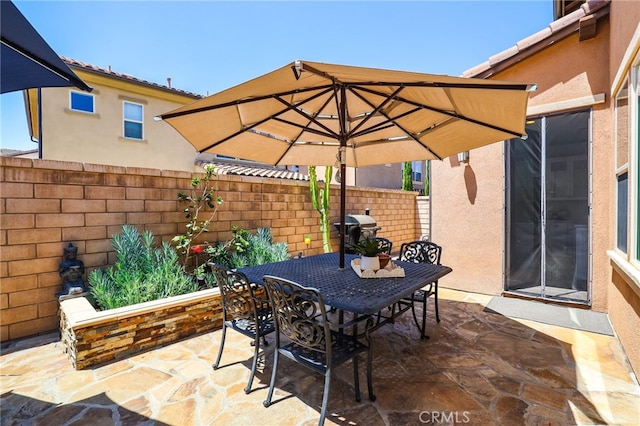 view of patio / terrace featuring fence, outdoor dining space, and grilling area