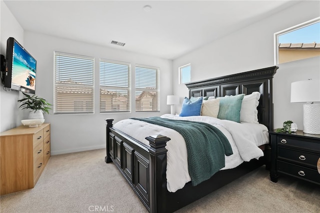 bedroom featuring baseboards, visible vents, and light colored carpet